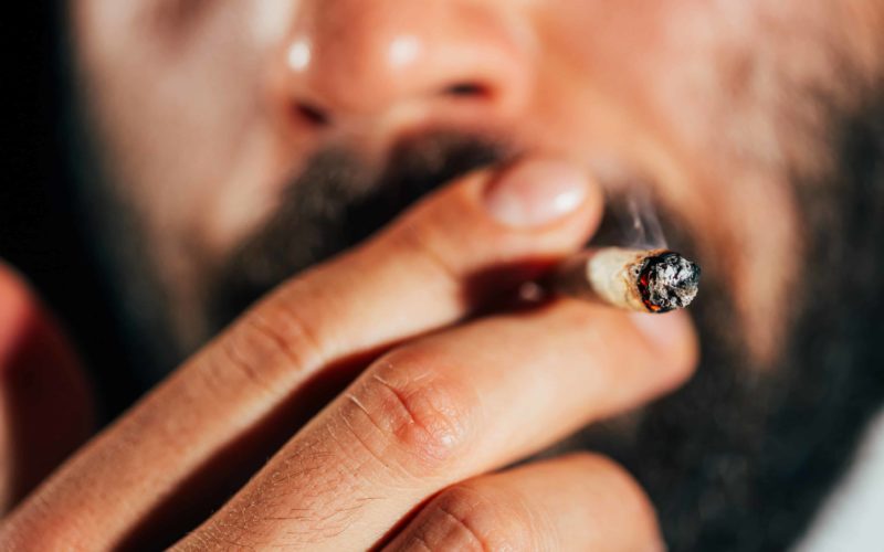 Man’s,Hand,Holding,And,Smoking,A,Marijuana,Joint,,,Close-up